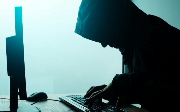 Hooded computer hacker hacking network