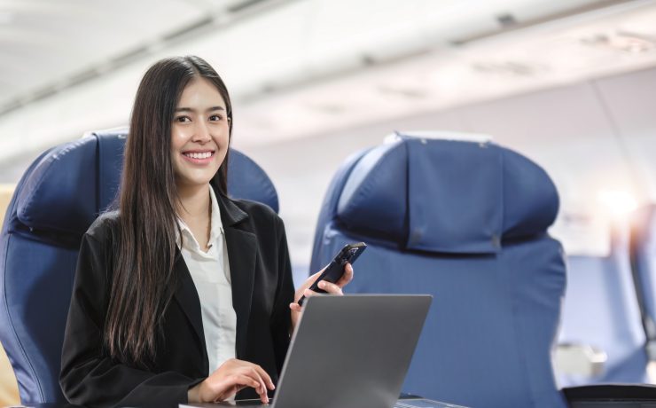 tourism and technology concept of business woman with smartphone and laptop