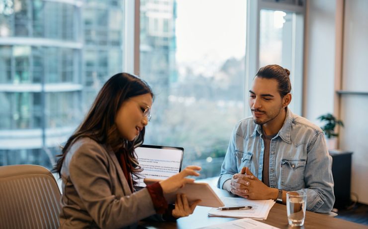 Young Hispanic man having a meeting with member of human resource team in the office.